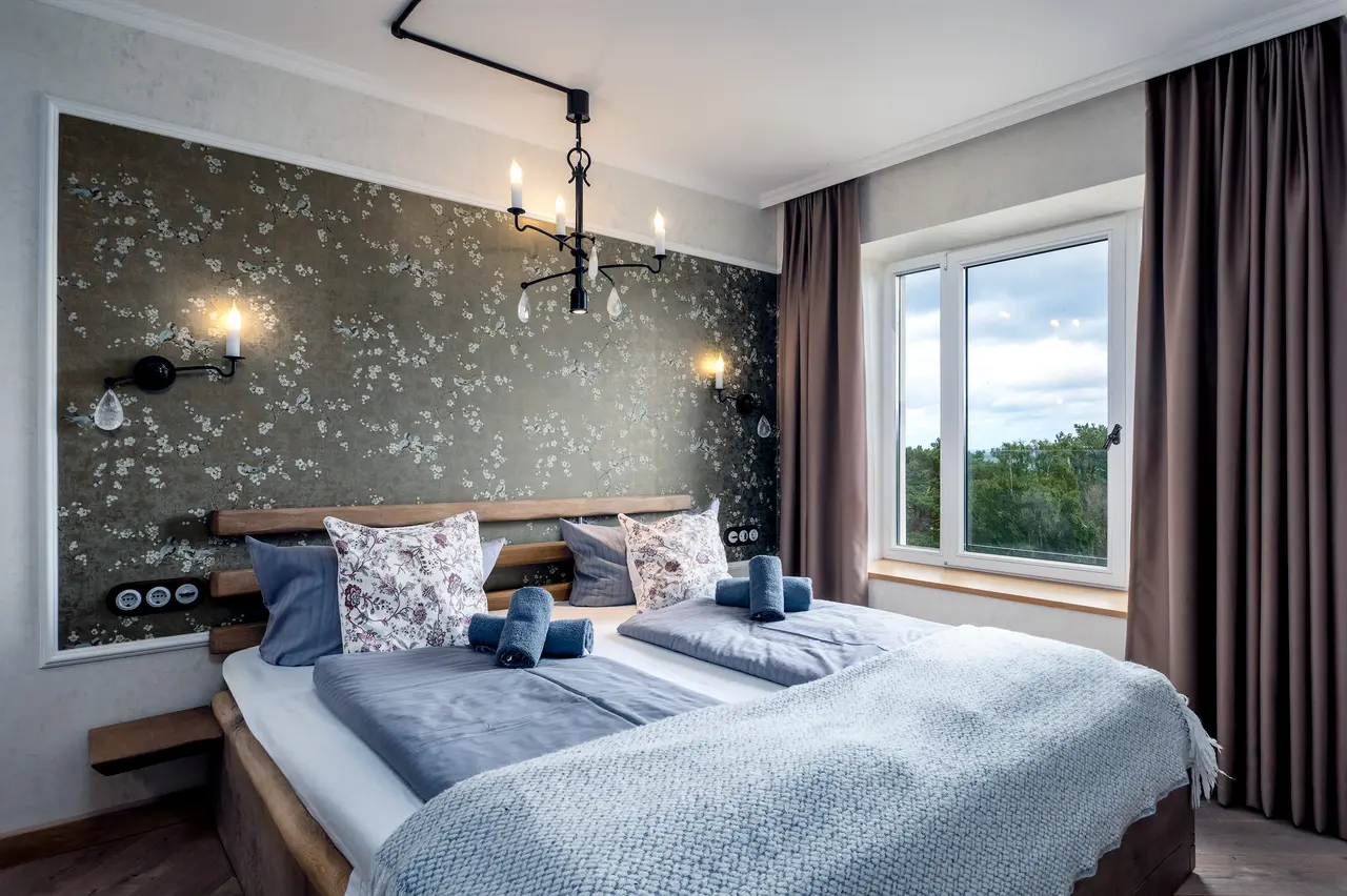 Perfekt gemachtes Bett mit weißer, gebügelter Bettwäsche in einer Ferienwohnung.