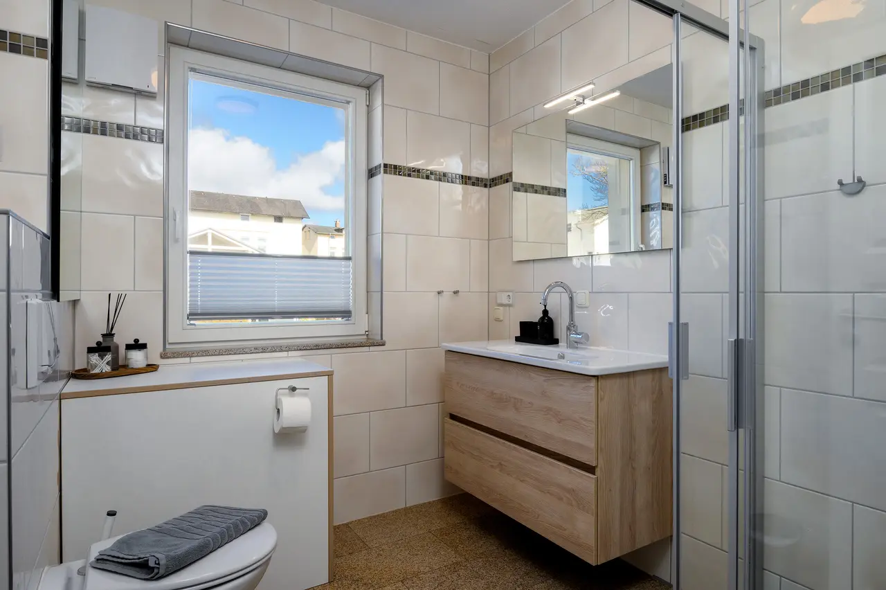 Fewo Seeblick Badezimmer. Professionelle Immobilienfotos der Ferienwohnung Seeadler; stimmungsvolle Schlafzimmer-Beleuchtung im "Nordic Cozy"-Stil.