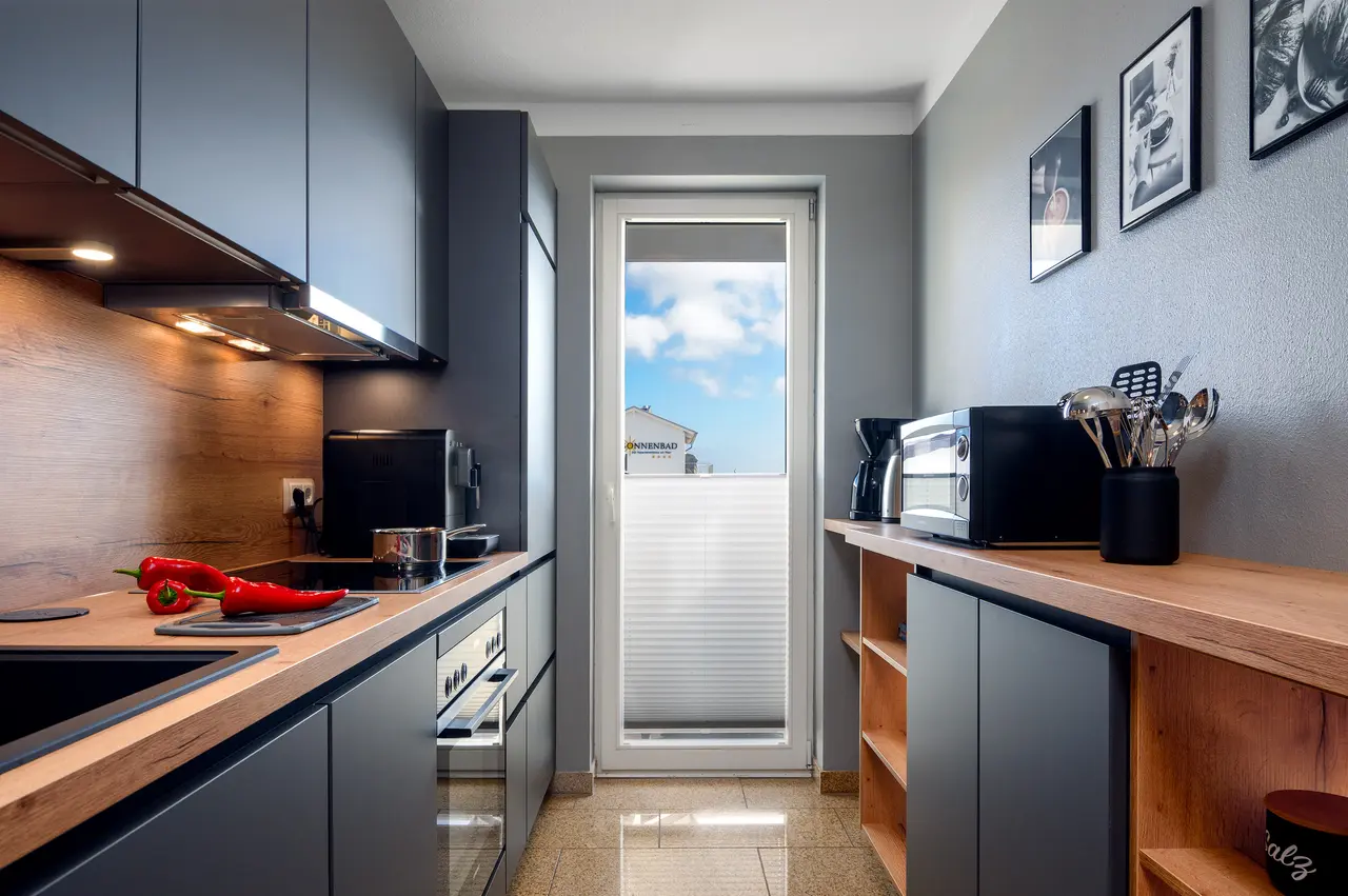 Fewo Seeblick Küche. Professionelle Immobilienfotos der Ferienwohnung Seeadler; stimmungsvolle Schlafzimmer-Beleuchtung im "Nordic Cozy"-Stil.