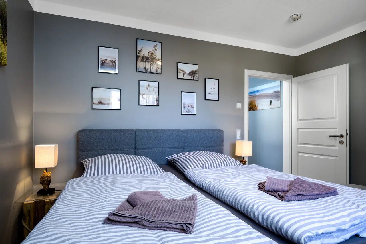 Fewo Seeblick Schlafzimmer. Professionelle Immobilienfotos der Ferienwohnung Seeadler; stimmungsvolle Schlafzimmer-Beleuchtung im "Nordic Cozy"-Stil.